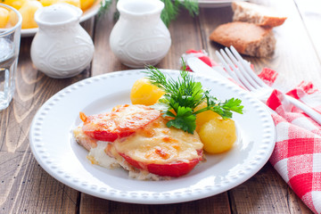 Baked pink salmon with tomato and cheese on a white plate with potatoes, horizontal