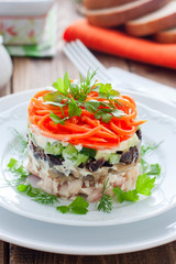 Salad with mushrooms, prunes, Korean carrots on a white plate, selective focus