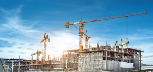 Panorama view at workers are working on large construction sites and many cranes are working in...