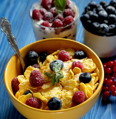 Healthy breakfast. corn flakes with raspberries and blueberries and granola with yogurt and berries.