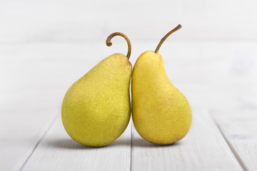 Two Fresh yellow Pears on a white wooden table