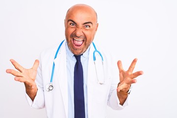 Middle age doctor man wearing stethoscope and tie standing over isolated white background celebrating crazy and amazed for success with arms raised and open eyes screaming excited. Winner concept