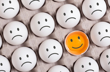 be different concept.smiling face among group of sad faces