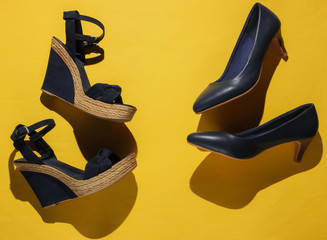 Stylish women's platform sandals, high heel shoes on yellow background. Studio shot. Minimalistic fashion still life. Top view