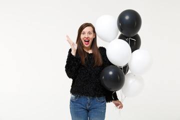 Fototapeta premium Young woman girl posing celebrating holding black and white air balloons isolated on white wall background studio portrait. Birthday holiday party people emotions lifestyle concept. Mock up copy space