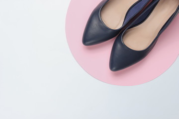 Classic women’s high heel shoes on white background with pink circle. Stylish shoes. Minimalistic fashion still life. Top view
