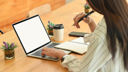 Close-up woman using mockup laptop and thinking ideas.