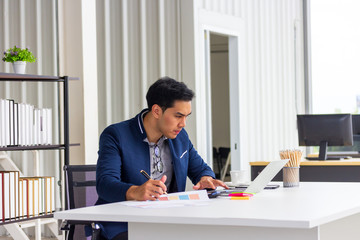 Young Asian businessmen watching the appointment book in the office