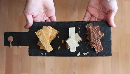 Person offering three types of Spanish turron on a slate