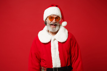 Cheerful elderly gray-haired mustache bearded Santa man in Christmas hat, sunglasses posing...