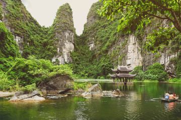 Naklejka premium Tourists on rowboat at the Trang An Landscape Complex in the Ninh Binh Province of Vietnam