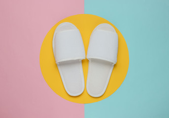 White slippers on a pastel colored background. Minimalistic fashion shot.