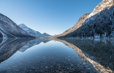 Fototapeta na wymiar Spiegelungen im Heiterwanger See im Winter, Tirol