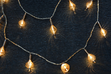 Fototapeta na wymiar Luminous Christmas garland of metal springs on a dark background