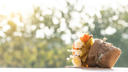 A bouquet of roses made of plastic wrapped in fabric, placed on a table.