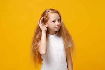 Curious little ginger kid girl 12-13 years old in white t-shirt isolated on yellow background...