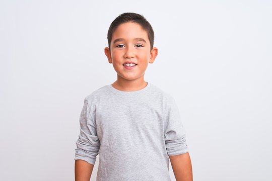 Beautiful kid boy wearing grey casual t-shirt standing over isolated white background with a happy and cool smile on face. Lucky person.