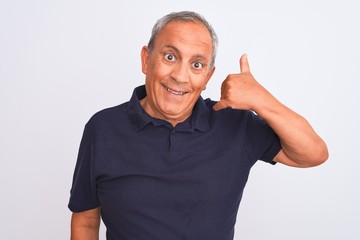 Senior grey-haired man wearing black casual polo standing over isolated white background smiling doing phone gesture with hand and fingers like talking on the telephone. Communicating concepts.
