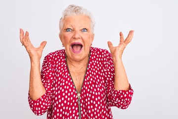 Senior grey-haired woman wearing red casual jacket standing over isolated white background celebrating crazy and amazed for success with arms raised and open eyes screaming excited. Winner concept