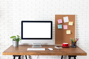 Mockup blank screen computer on a wooden desk. desktop empty white screen, with workspace and office supplies on table