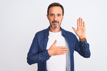 Middle age handsome man wearing blue denim shirt standing over isolated white background Swearing...