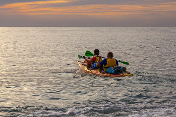 Fototapeta na wymiar athletes kayakers (man and woman) go on a kayak trip on the Bay of Black sea to meet the beautiful dawn. Amazing views. Perfect activity for holidays. The Peninsula of the Crimea, Russia, Ukraine.