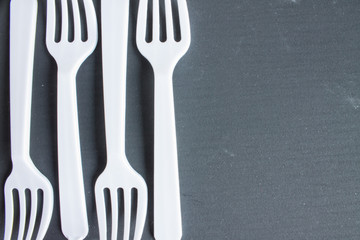 Plastic white forks on grey background