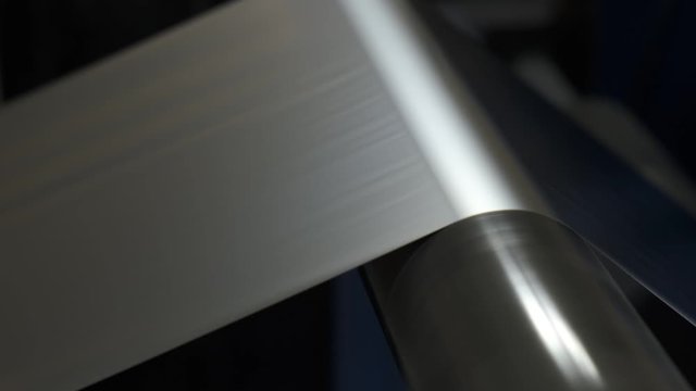 Close-up of production line in factory floor, conveyor produces packaging polyethylene, plastic bags, cling film, rotating shaft, production process, polypropylene, industry, automation of production