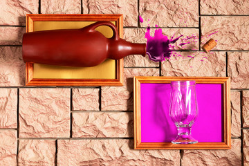 On the brick wall hang two improvised complementary paintings. From the bottle in one picture takes...