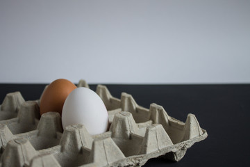 Two eggs in a tray on a black and white background