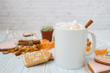 Christmas background - side view of hot chocolate with marshmallows, cinnamon stick in a white mug. Hot cocoa drink for Christmas and winter holidays with gingerbread, nuts, festive decor.