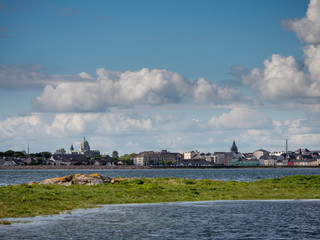 Galway city and bay, cloudy sky, Cathedral dome. blue water, sunny day.