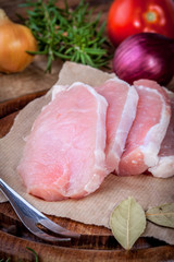 Fresh raw meat sliced on a wooden chopping board.