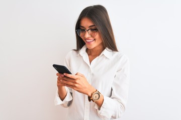 Beautiful businesswoman wearing glasses using smartphone over isolated white background with a happy face standing and smiling with a confident smile showing teeth