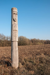 Wooden idol Slavic goddess Lada on a background of blue sky