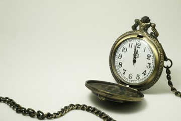 Old pocket watch on white background.