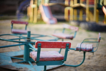Playground with an old carousel in the sand closeup.