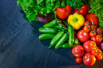 Vegetables on a dark background. Vegetable Flatley. Still life of fresh vegetables. Cucumbers, tomatoes, lettuce, onions, peppers. Vegetarianism. Appetizer of fresh produce. Snack. Garnish.