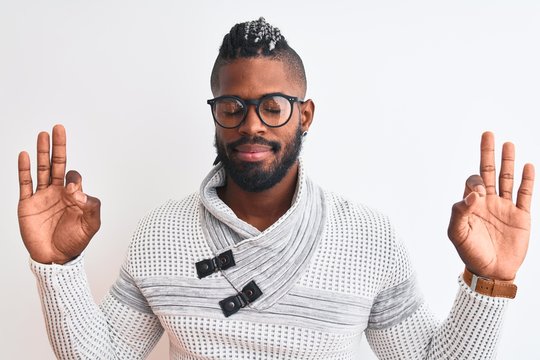 African american man wearing grey sweater and glasses over isolated white background relax and smiling with eyes closed doing meditation gesture with fingers. Yoga concept.