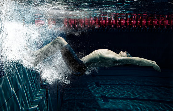Professional male swimmer in action inside swimming pool