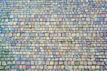 Background of paving stones of different shapes and colors of stones