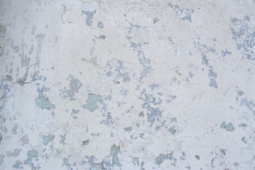 Light blue old concrete wall with partially peeling paint