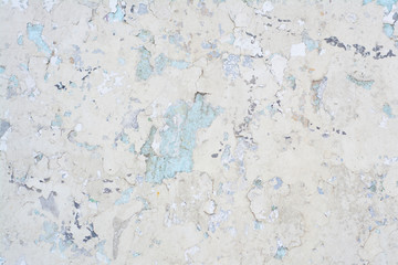 Light blue old concrete wall with partially peeling paint