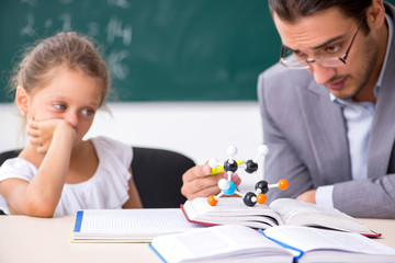 Teacher with young girl in the classroom
