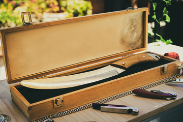 Briefcase with saber to uncork bottles of wine and champagne in the traditional style, through the...