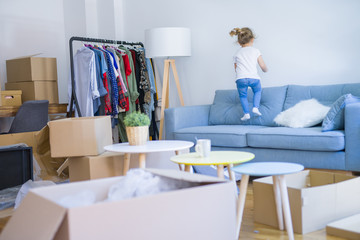 Beautiful toddler child girl jumping on the sofa