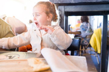 Beautiful toddler child girl sitting on baby highchair  crying and screaming