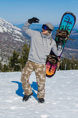 Young snowboarder riding in the mountains on a snowboard.