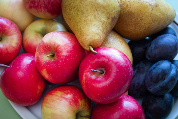 Fresh apples, plums, pears. Raw fruits and vegetables backgrounds, top view, part of a set of healthy organic fresh products.