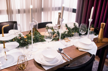Beautiful table setting for Christmas dinner. Served table setting for celebrating Christmas or New Year.
